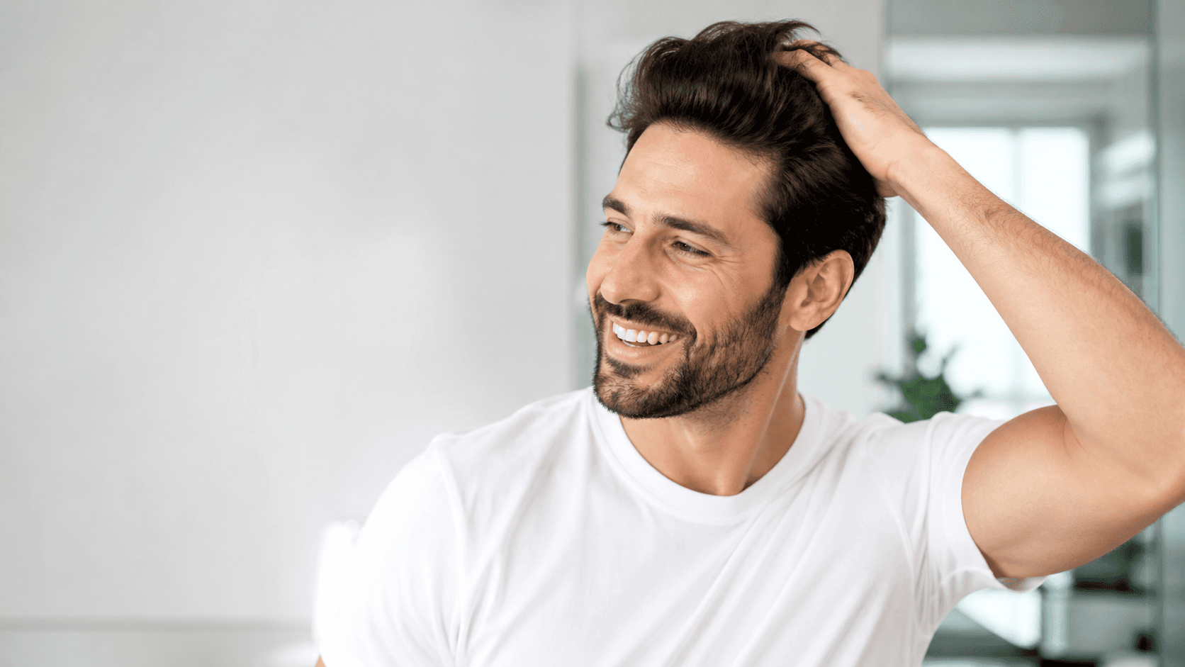 Man confidently running hand through hair